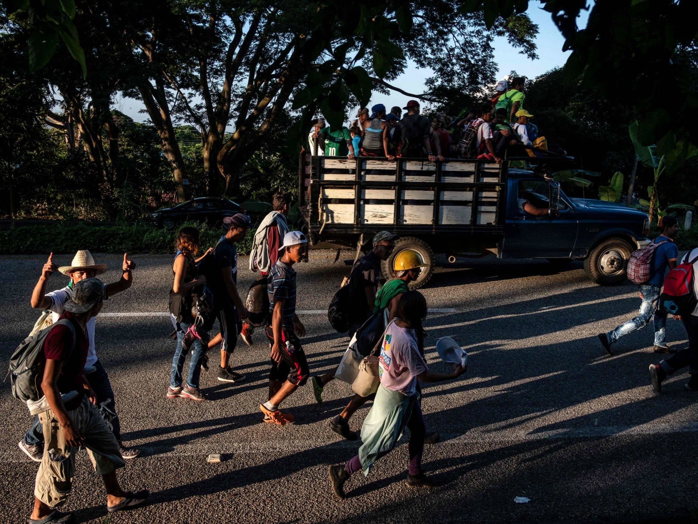 Honduran migrants heading in a caravan to the US, walk near Mapastepec, southern Mexico on 25 October 2018. (Photo by Guillermo Arias / AFP)GUILLERMO ARIAS