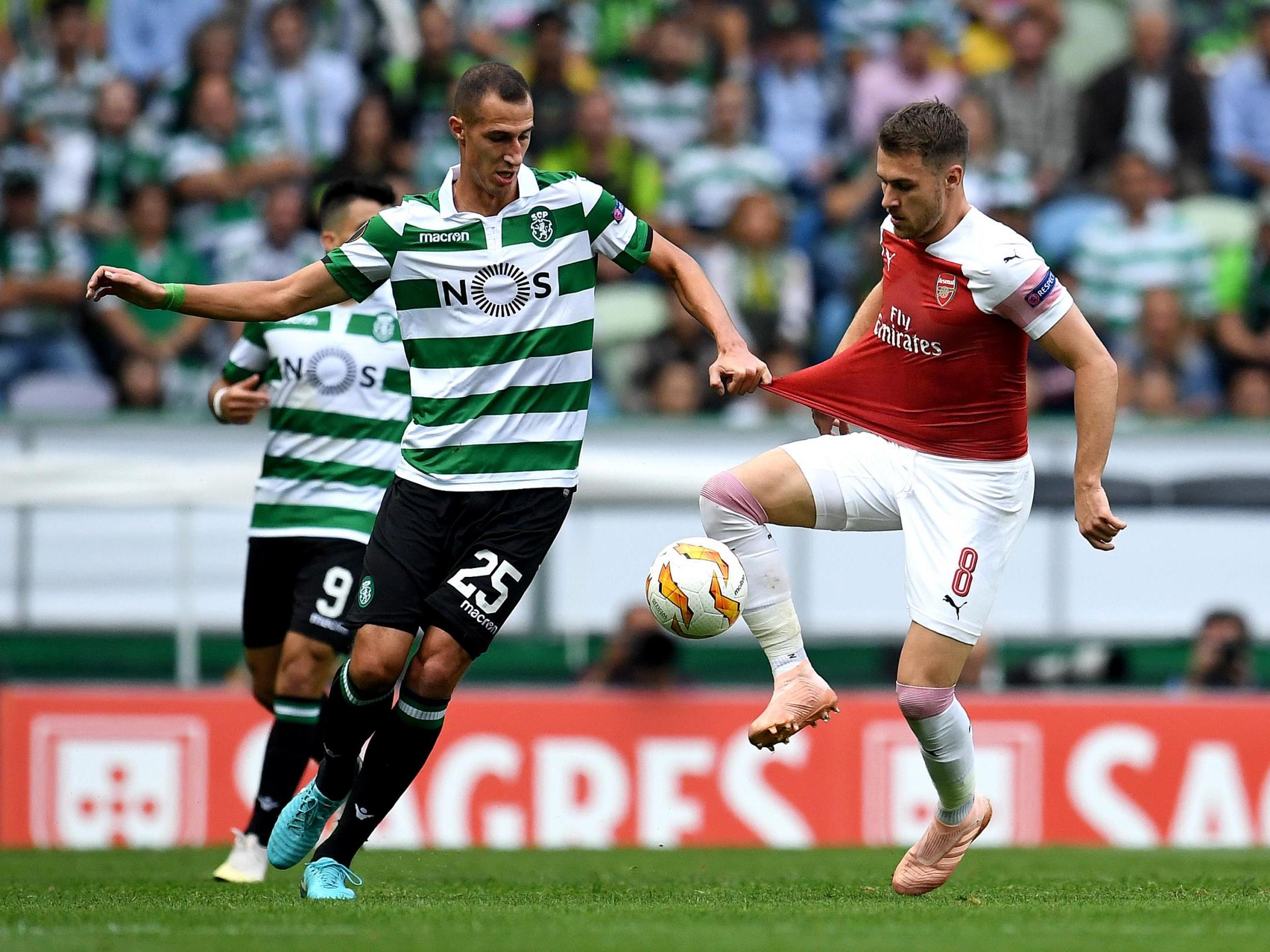 Aaron Ramsey controls the ball while under pressure from Radosav Petrovic