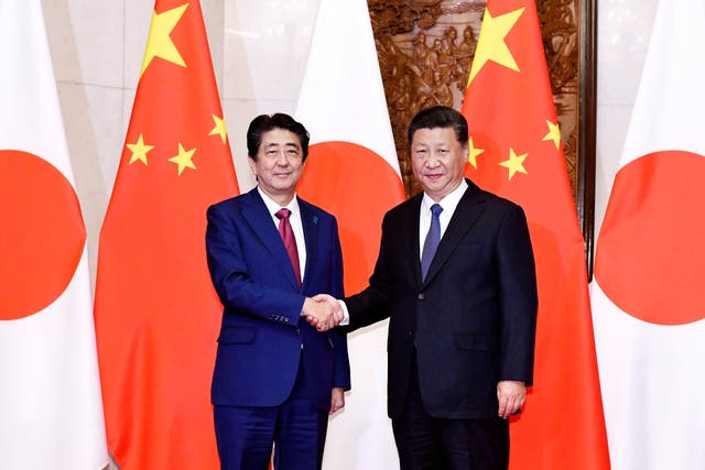 Japanese Prime Minister Shinzo Abe (left), poses with Chinese President Xi Jinping for a photo before a meeting at the Diaoyutai State Guesthouse in Beijing Friday 26 October 2018 (Kyodo News via