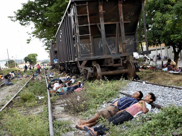 Members of the migrant caravan rest on the train tracks in Arriaga, Mexico
