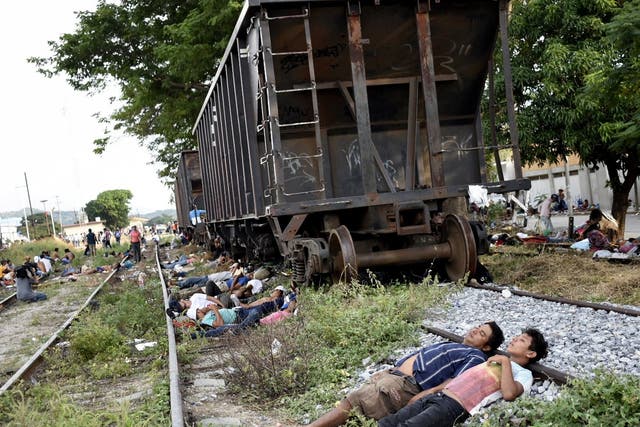 Members of the migrant caravan rest on the train tracks in Arriaga, Mexico
