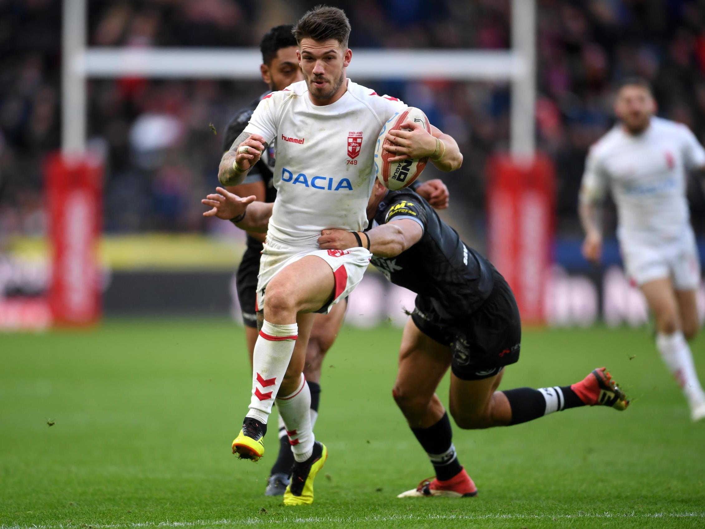 Oliver Gildart breaks free of a tackle before scoring for England