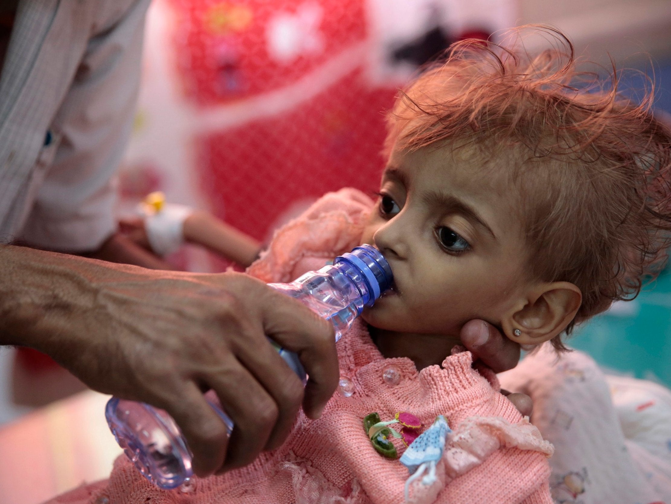 A father gives water to his malnourished daughter at a feeding centre in a hospital in Hodeidah, Yemen