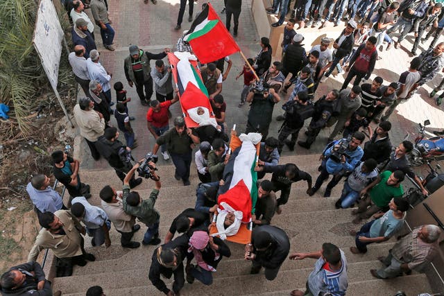 Palestinian mourners carry the bodies, draped in their national flag, of two of the three teenagers who were killed in an Israeli strike during their funeral in Deir el-Balah in the central Gaza Strip Photo: MAHMUD HAMS/AFP/Getty Images