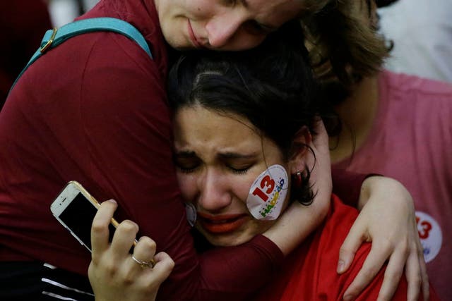 A supporter of Workers' Party presidential candidate Fernando Haddad embraces a fellow weeping supporter
Nelson Antoine