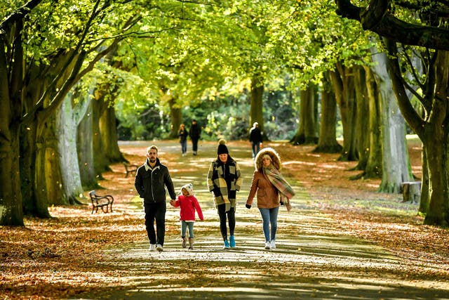 People walk through windblown leaves in Clifton, Bristol, as temperatures across the country begin to fall