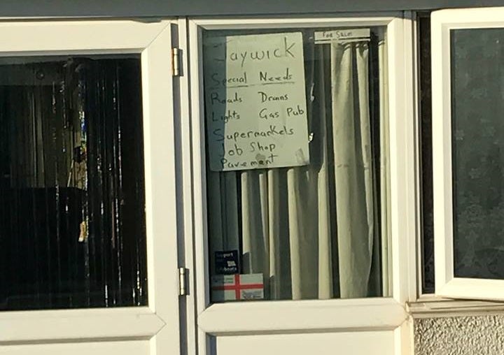 ‘Jaywick Special Needs: Roads, Lights, Supermarkets, Gas, Pub, Jobs, Shops, Pavement and dreams’, a handmade sign on a resident’s window in Jaywick (Tom Thornton )