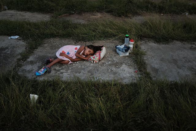 A child sleeps as members of the Central American caravan settle in for the night in a abandoned motel in Matias Romero Avendando, Mexico
