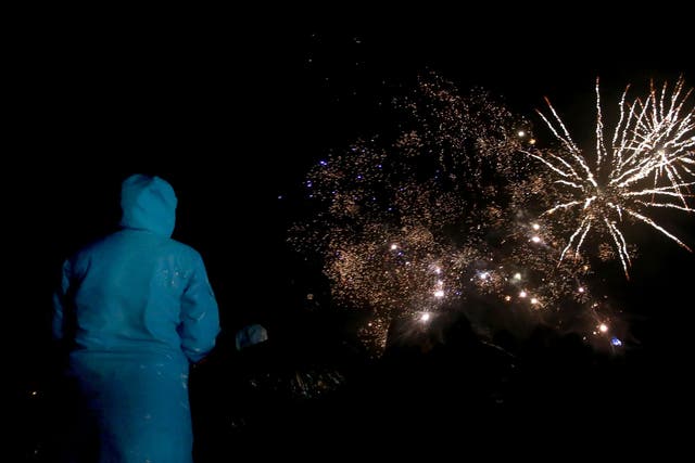 People watch the fireworks at Shell Island, near Barmouth during the wind and the rain.