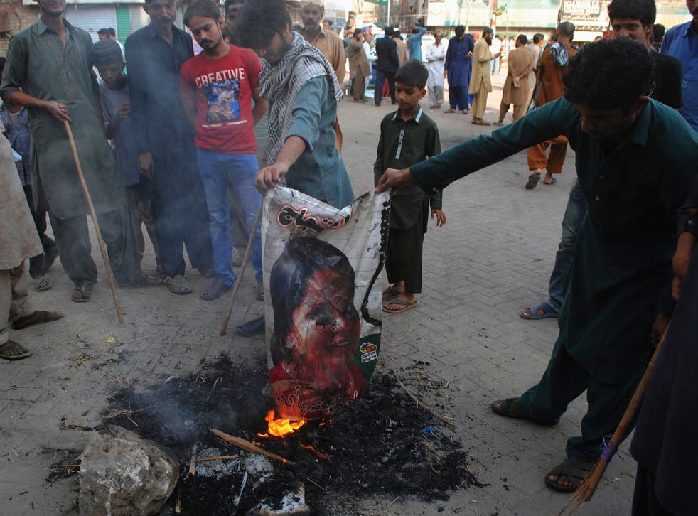 Islamists burn a poster of Asia Bibi in protest at her acquittal for blasphemy
