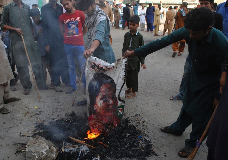 Islamists burn a poster of Asia Bibi in protest at her acquittal for blasphemy