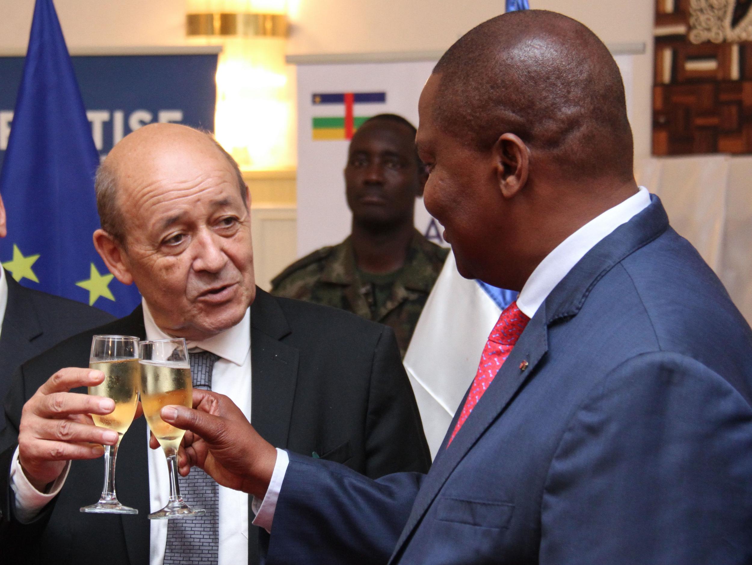 French Foreign Affairs Minister Jean-Yves Le Drian (left) toasts with Central African Republic's President Faustin Archange Touadera on November 2, 2018 in Bangui