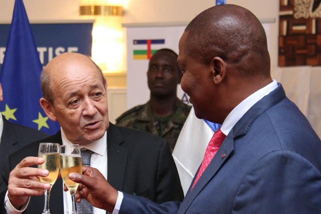French Foreign Affairs Minister Jean-Yves Le Drian (left) toasts with Central African Republic's President Faustin Archange Touadera on November 2, 2018 in Bangui