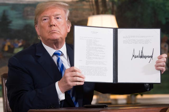 Donald Trump signs a document reinstating sanctions against Iran after announcing withdrawal from the nuclear deal in May 2018