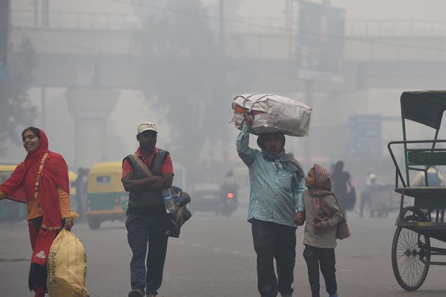 A man carries his belongings in heavy smog in Delhi on 5 November