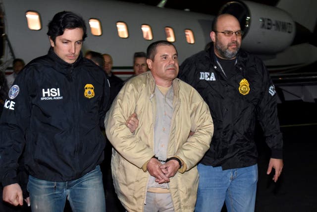 Authorities escort Joaquin "El Chapo" Guzman, centre, from a plane in New York, 2017