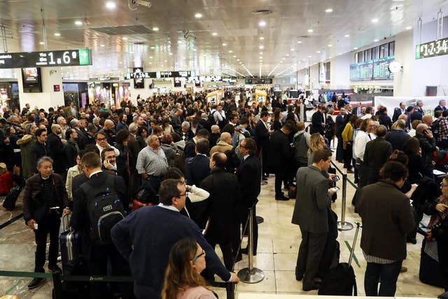 Travelers wait for information after trains evacuated at Sants station