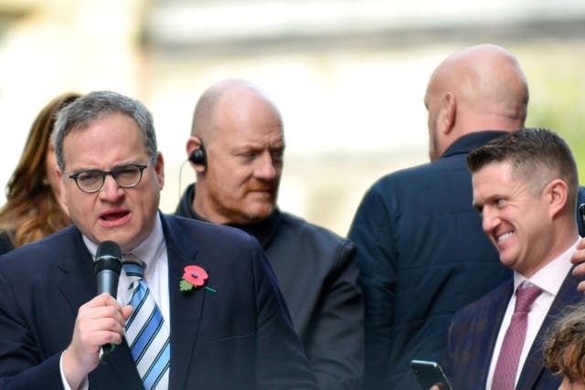 Ezra Levant (left) speaks on a stage outside the Old Bailey in support of Tommy Robinson (right) on 23 October