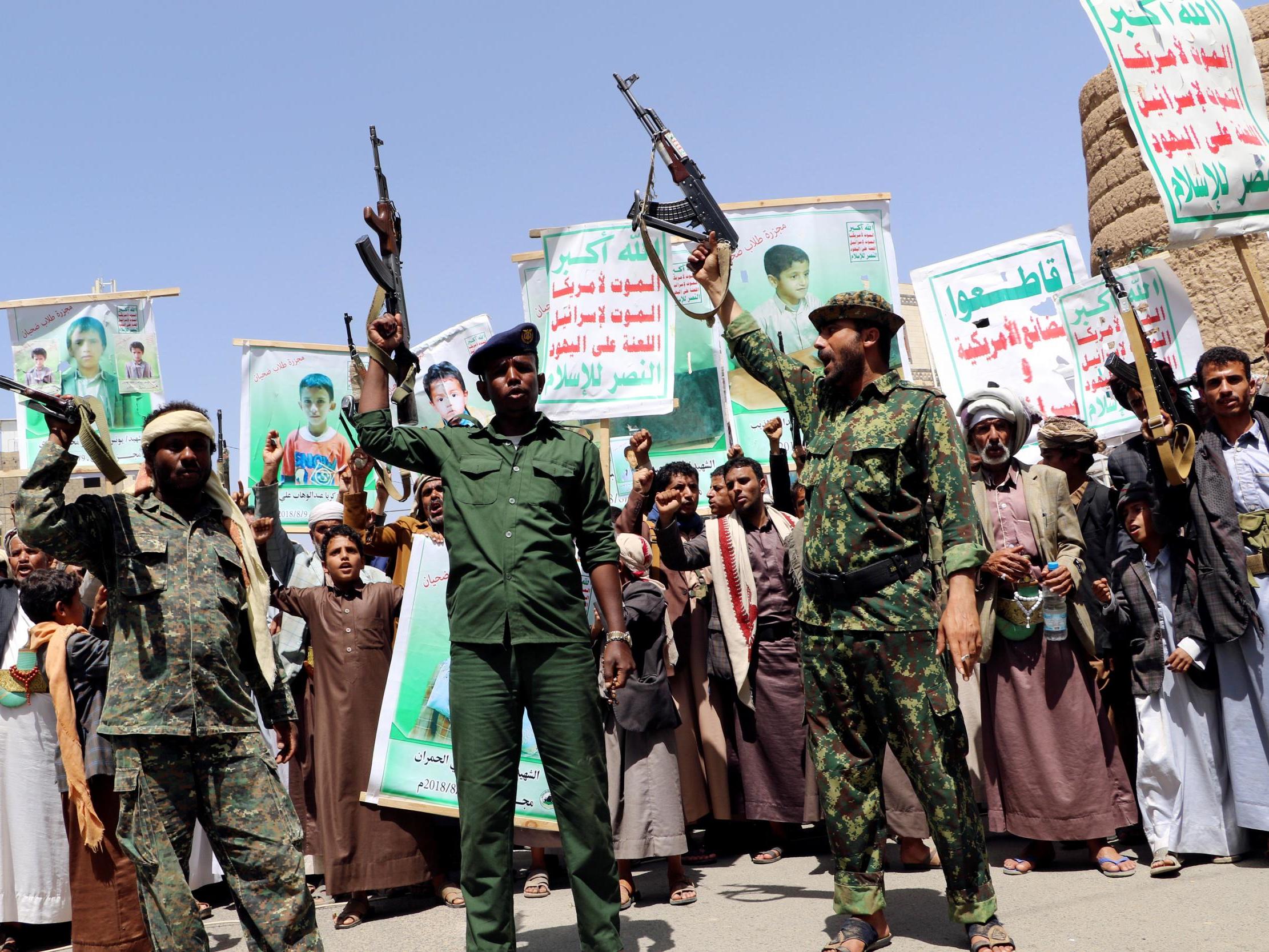 Houthi soldiers protest an offer by the Saudi-led coalition to pay compensation for victims of an airstrike in Saada, Yemen
