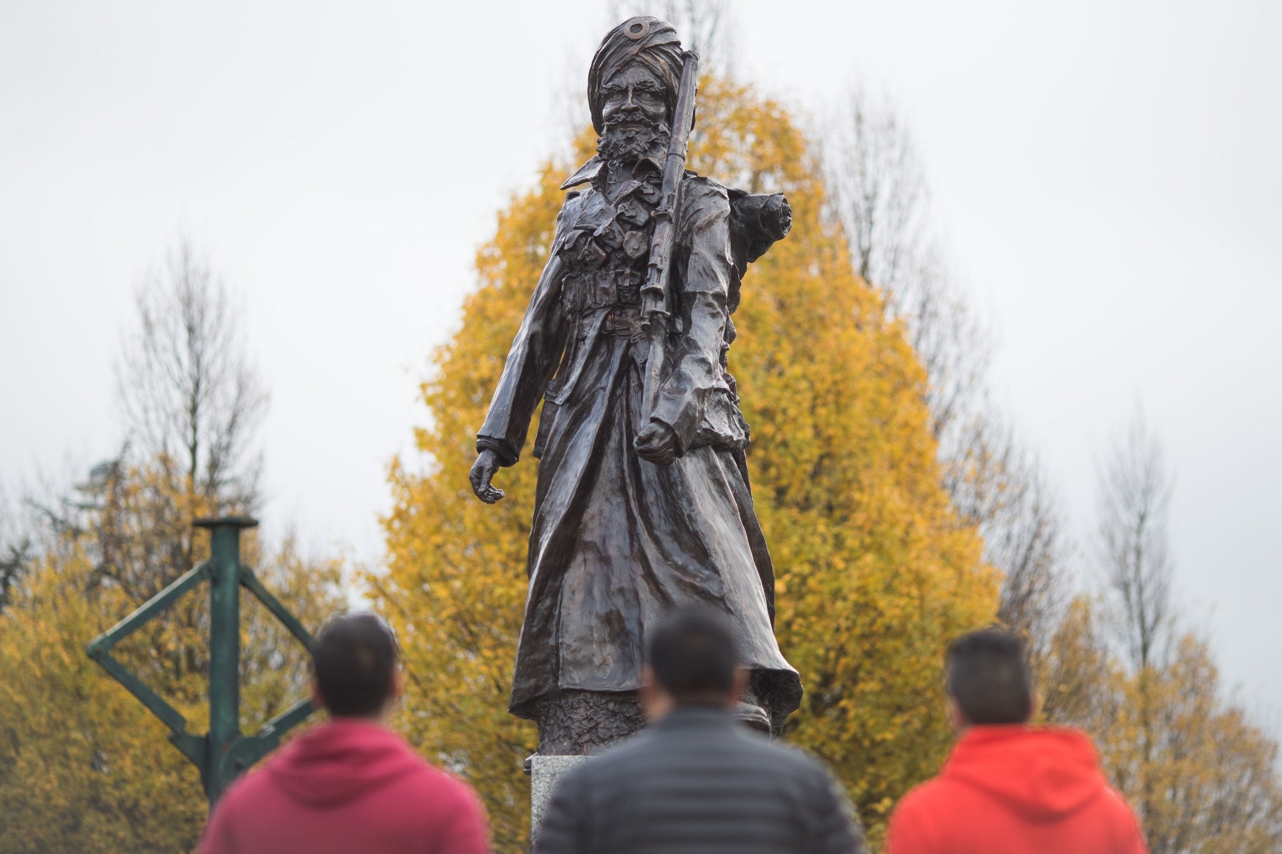 Three men take a moment to look at the monument in Smethwick