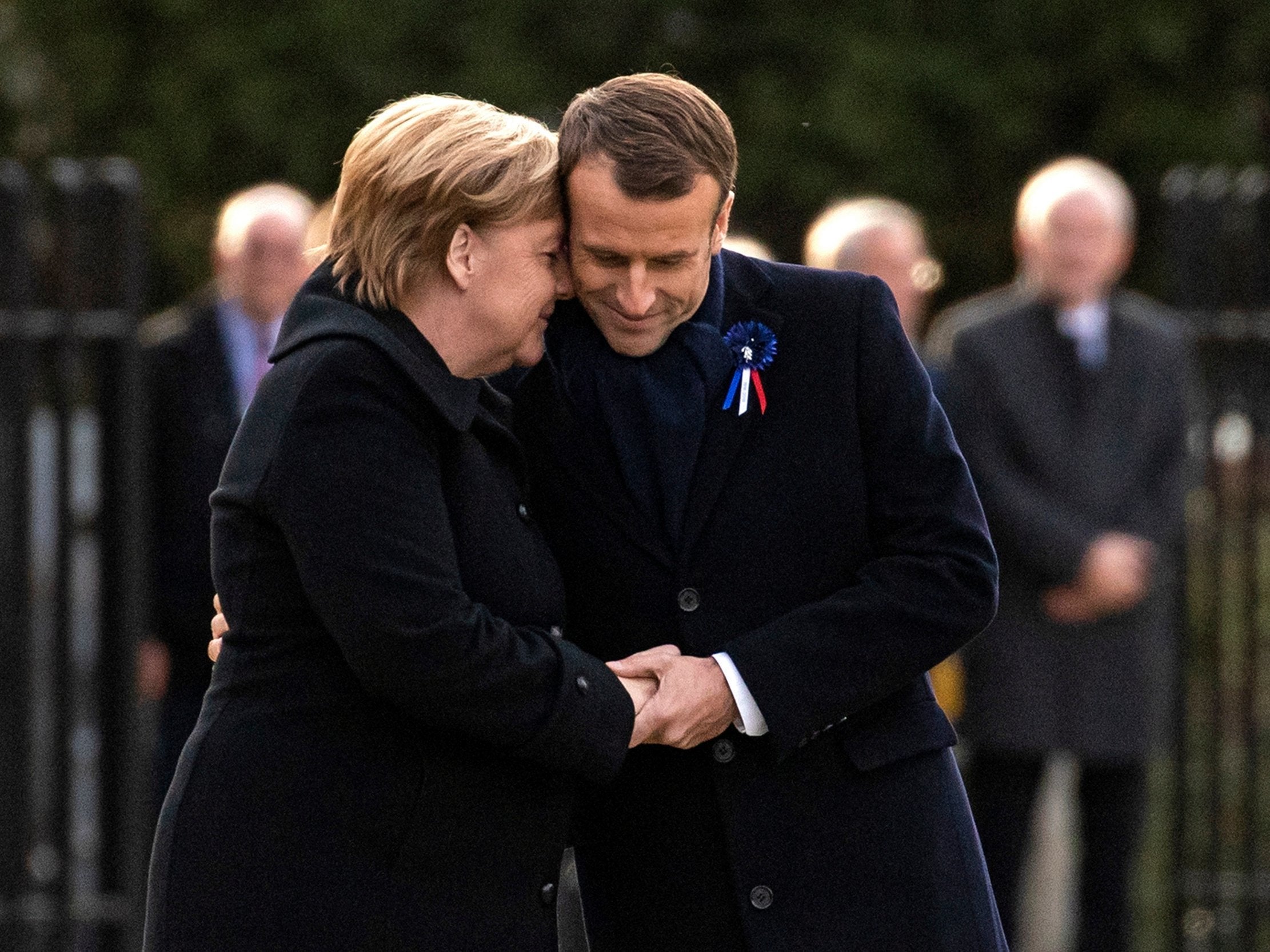 Ms Merkel and Mr Macron embrace at ceremony