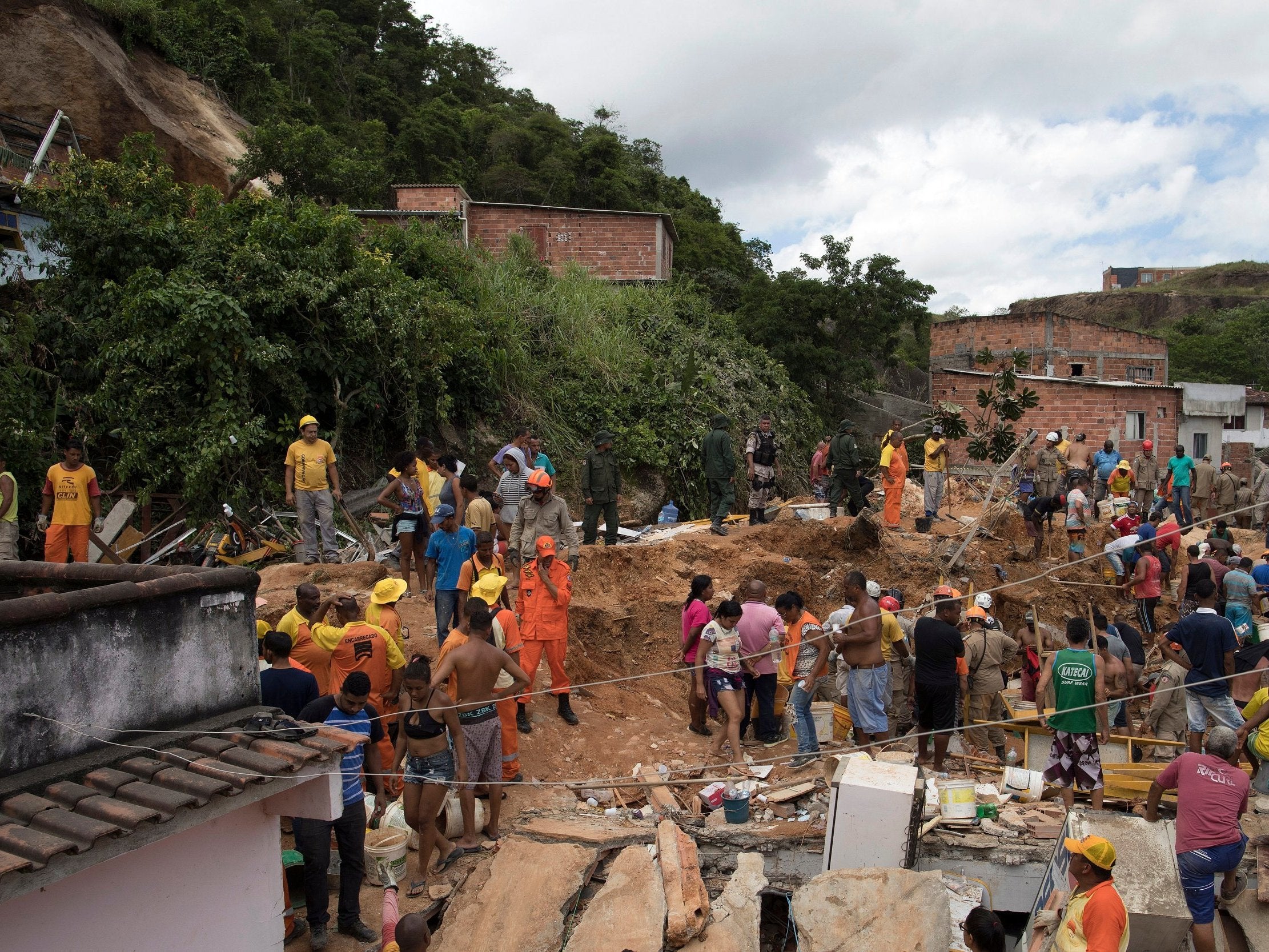 Residents and firefighters work to clear debris after a mudslide in Niteroi