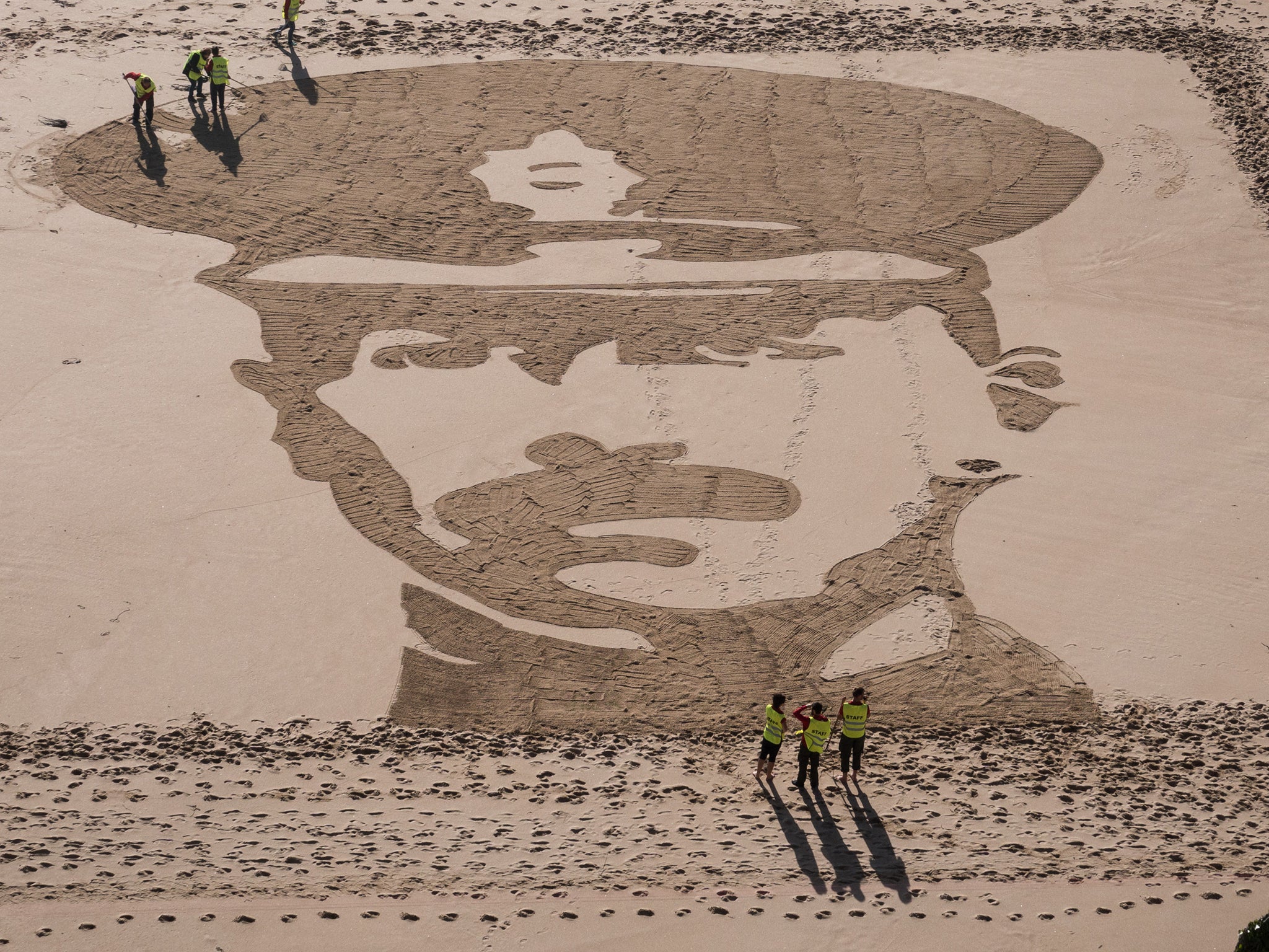 People on Porthcurno beach in Cornwall work on portrait of Lieutenant Richard Charles Graves-Sawle (Getty )