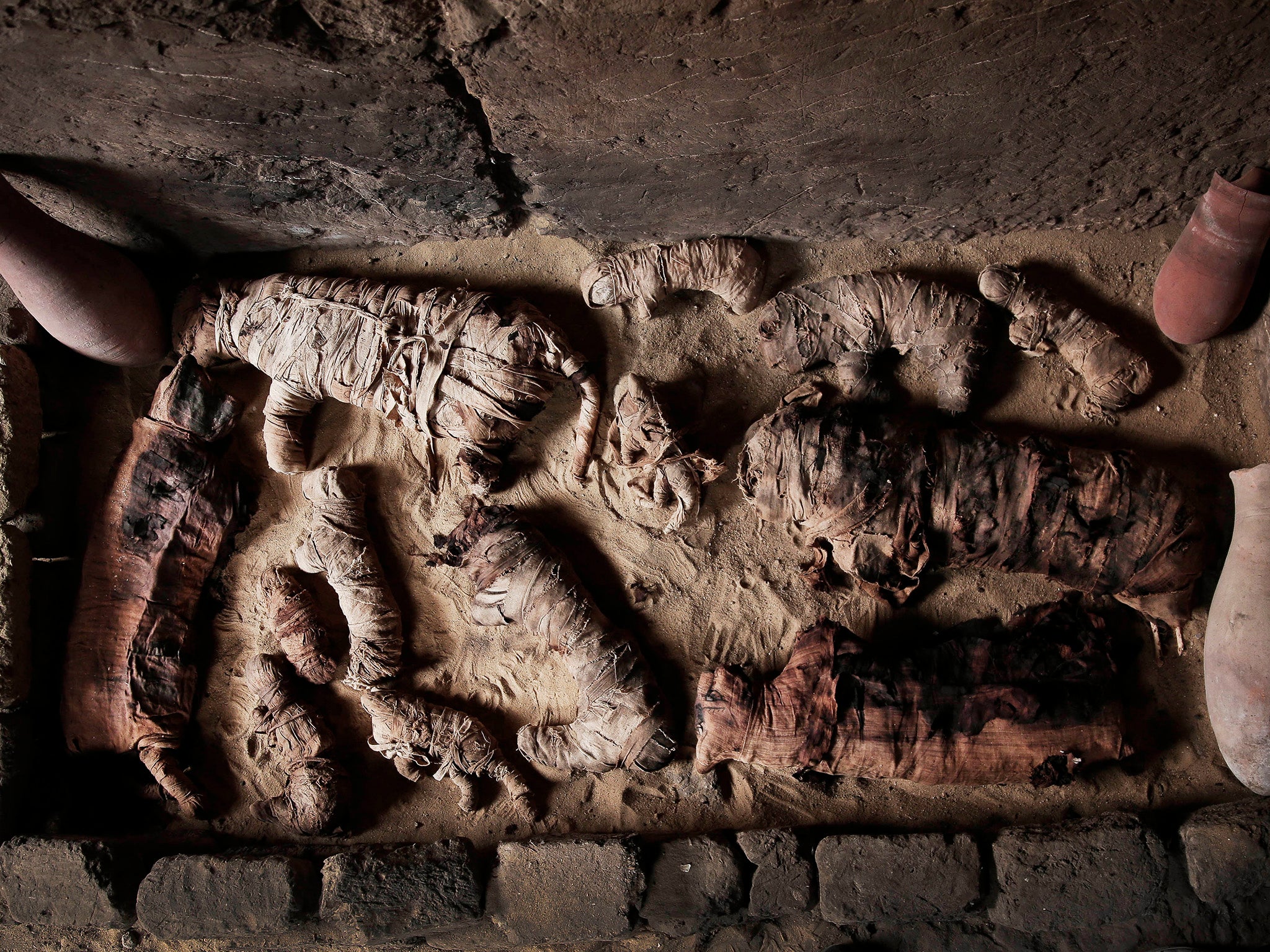 An archaeologist working on a statue inside a tomb, at an ancient necropolis near Egypt's famed pyramids in Saqqara