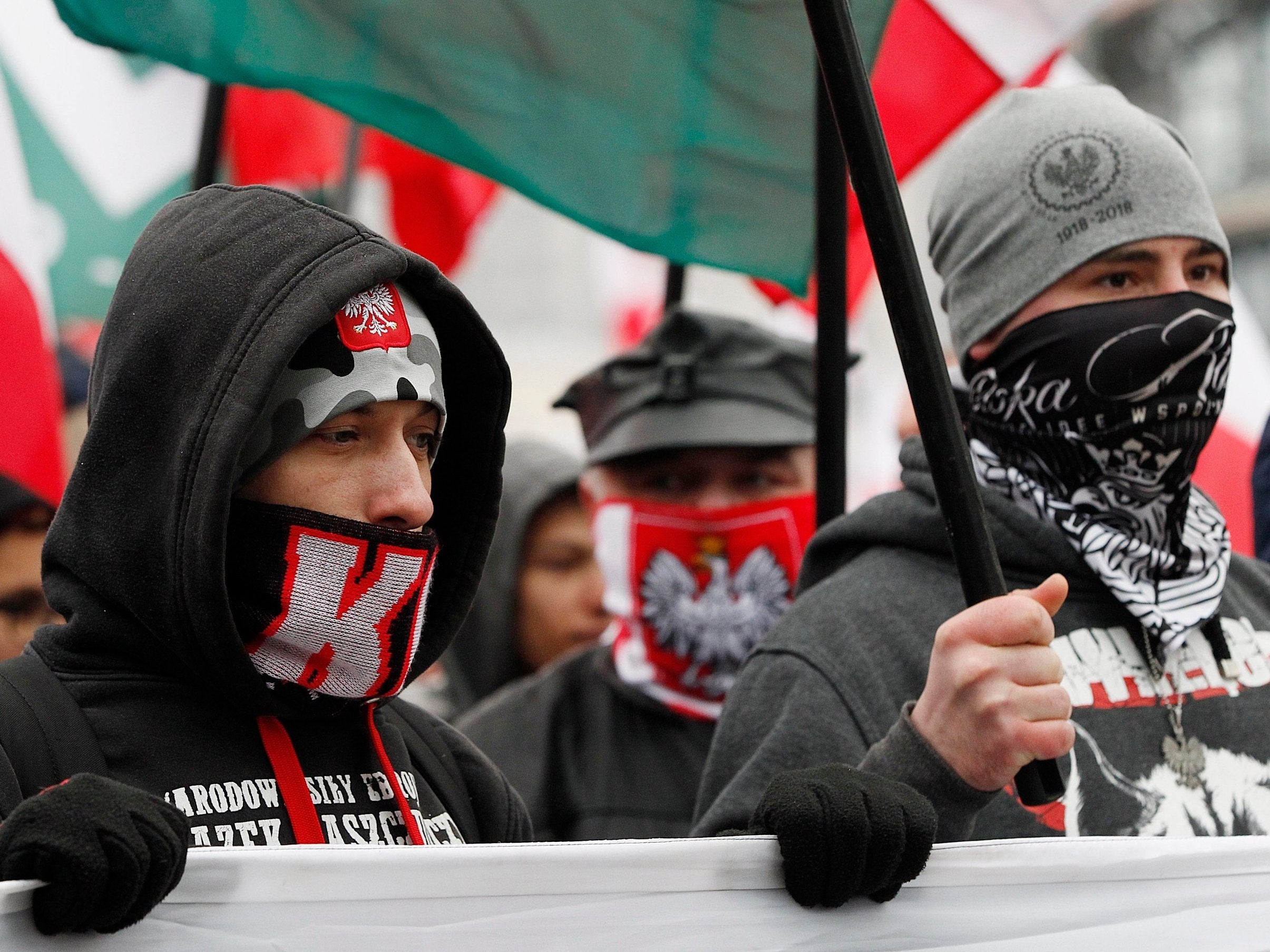Masked members of radical right-wing groups wave flags at independence march