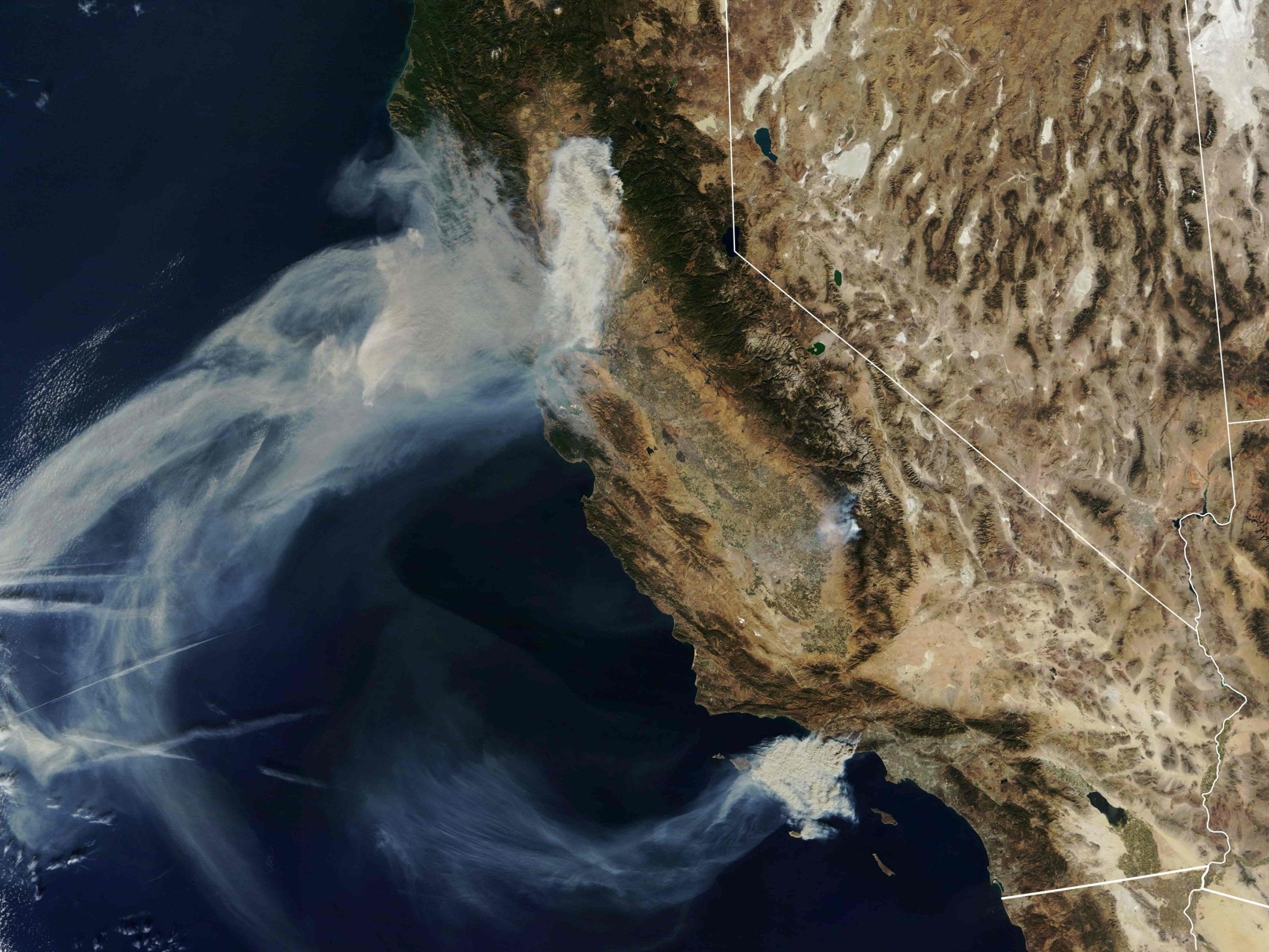 Nasa Earth Observatory satellite image captured on 9 November, 2018, shows the Camp Fire (top) burning in Paradise, California, while the Hill and Woolsey Fires (bottom) burn in nouthern California