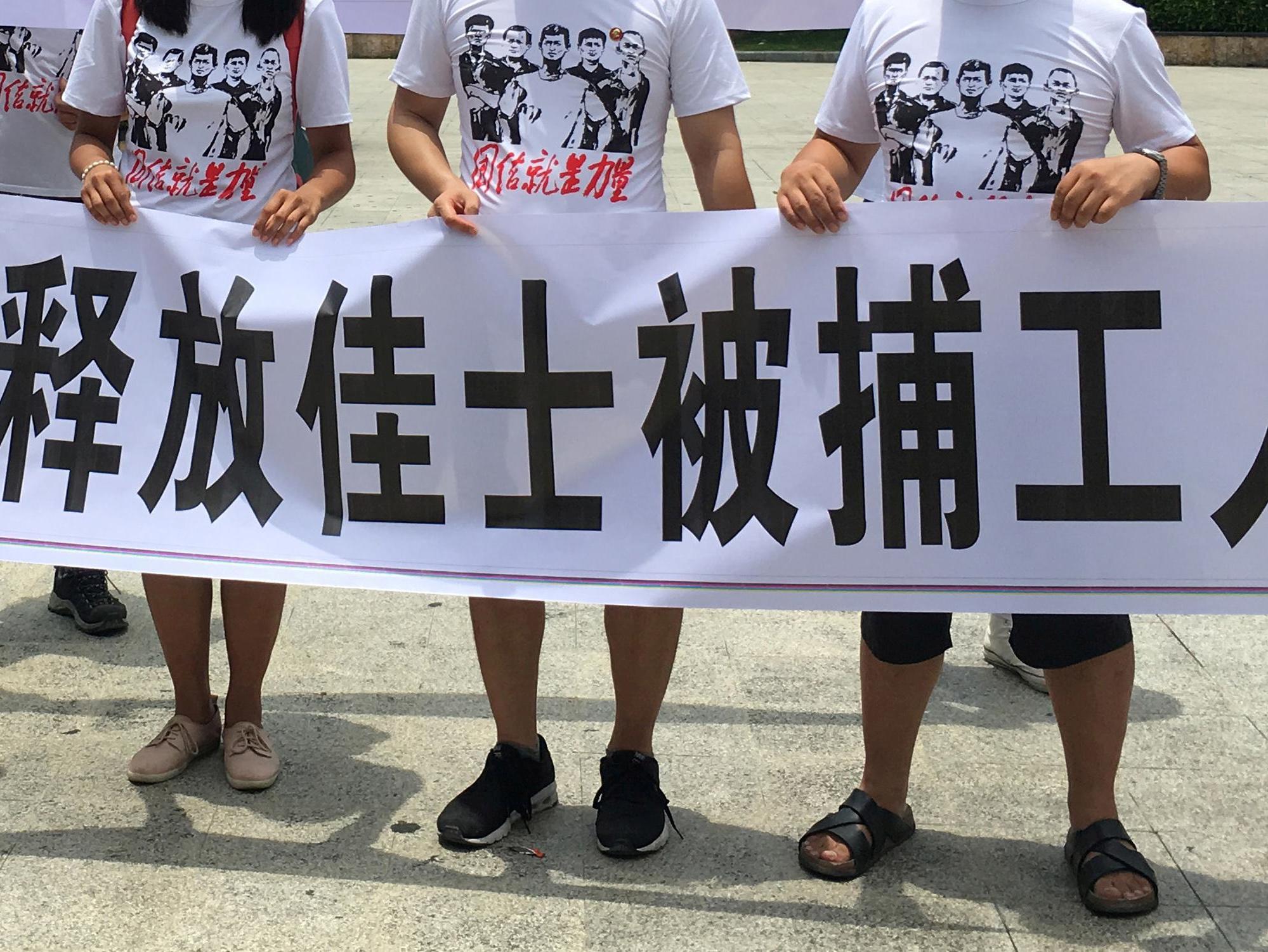 People hold banners at a demonstration in support of factory workers of Jasic Technology, in Pingshan district, China on 6 August 2018
