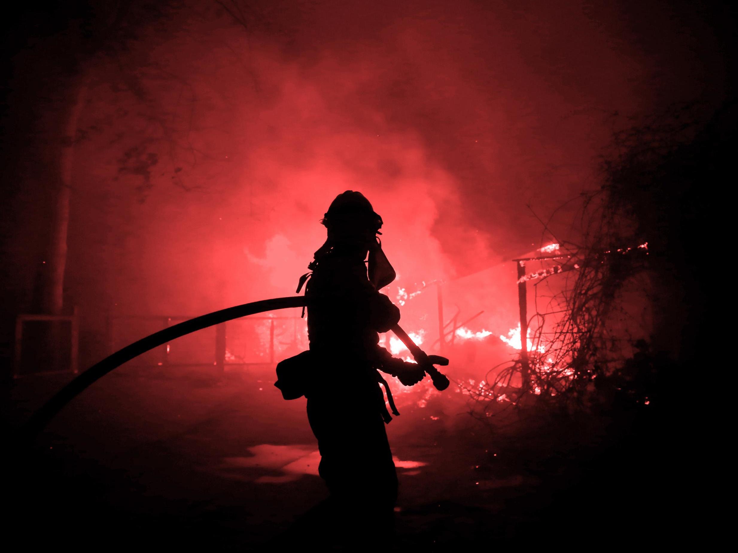 A firefighter battles the Woolsey Fire in Malibu, California