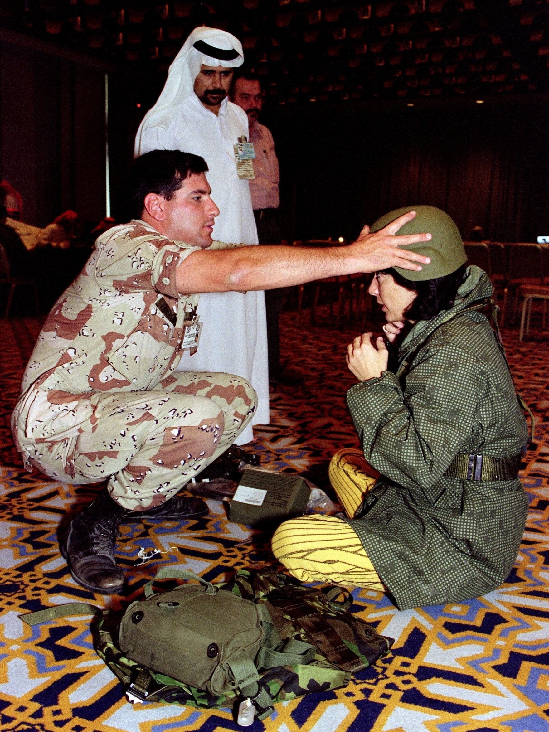 A US army officer adjusts the helmet of CNN reporter Christiane Amanpour during the Gulf War in 1991