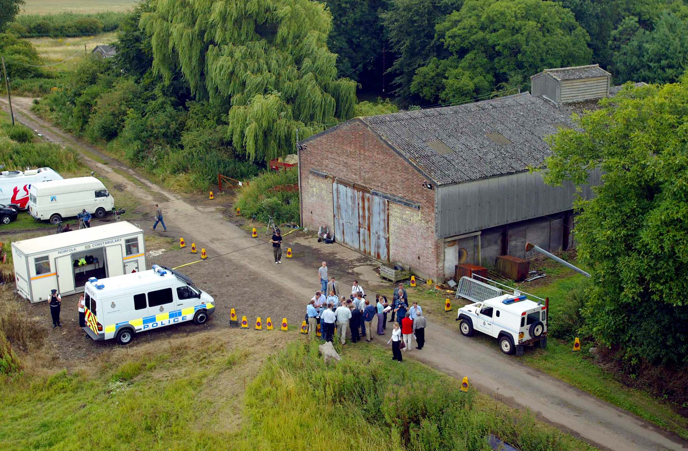 Aerial view shows police and members of the media gathering at the home of British farmer Tony Martin, "Bleak House", after his release from custody, in Norfolk, eastern England, July 28, 2003.