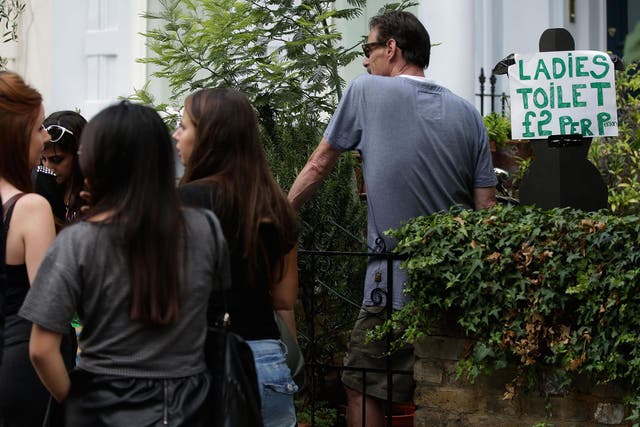 People queue to use a residential toilet being rented out in one of the streets surrounding the Notting Hill Carnival (Matthew Lloyd