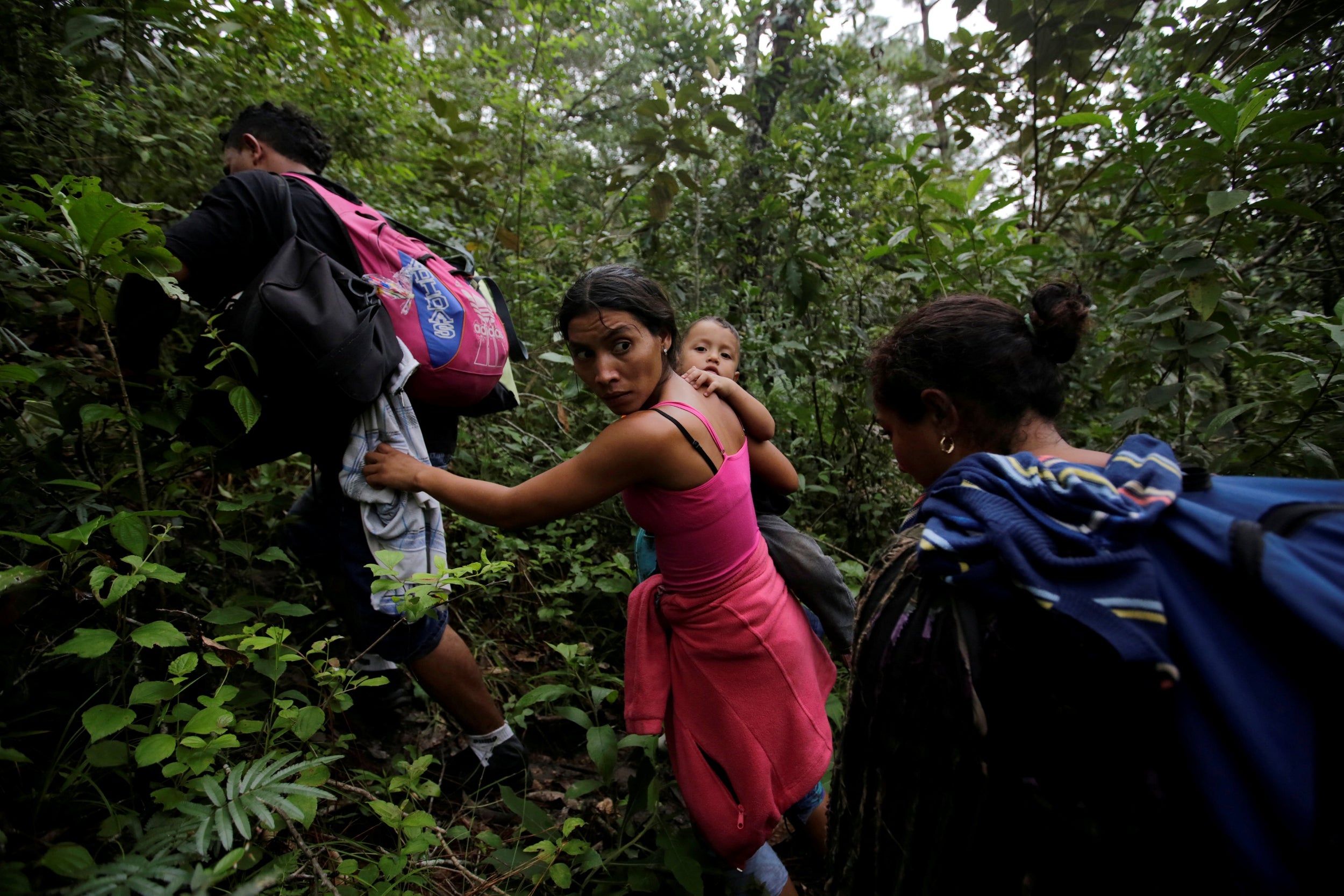 Honduran migrants hike in a forest after crossing the Lempa river, between Honduras and Guatemala, to join the caravan trying to reach the US