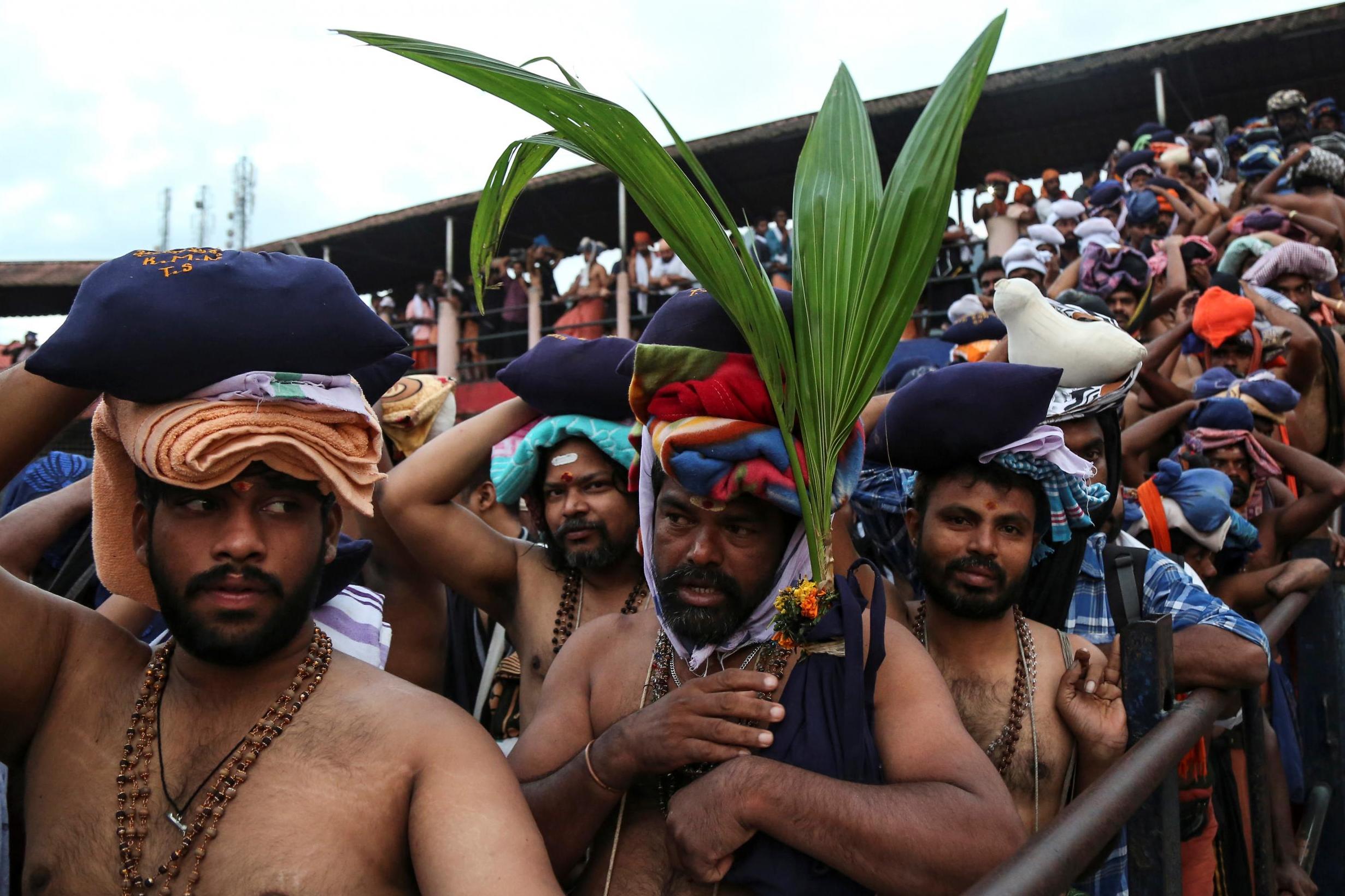A Hindu devotee holds a coconut plant as he waits with others in queues inside the premises of the Sabarimala temple in Pathanamthitta district in the southern state of Kerala, India, 18 October 2018. (Sivaram V /