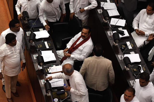 Sri Lanka's former president and currently appointed prime minister Mahinda Rajapaksa (C) attends the parliament session in Colombo