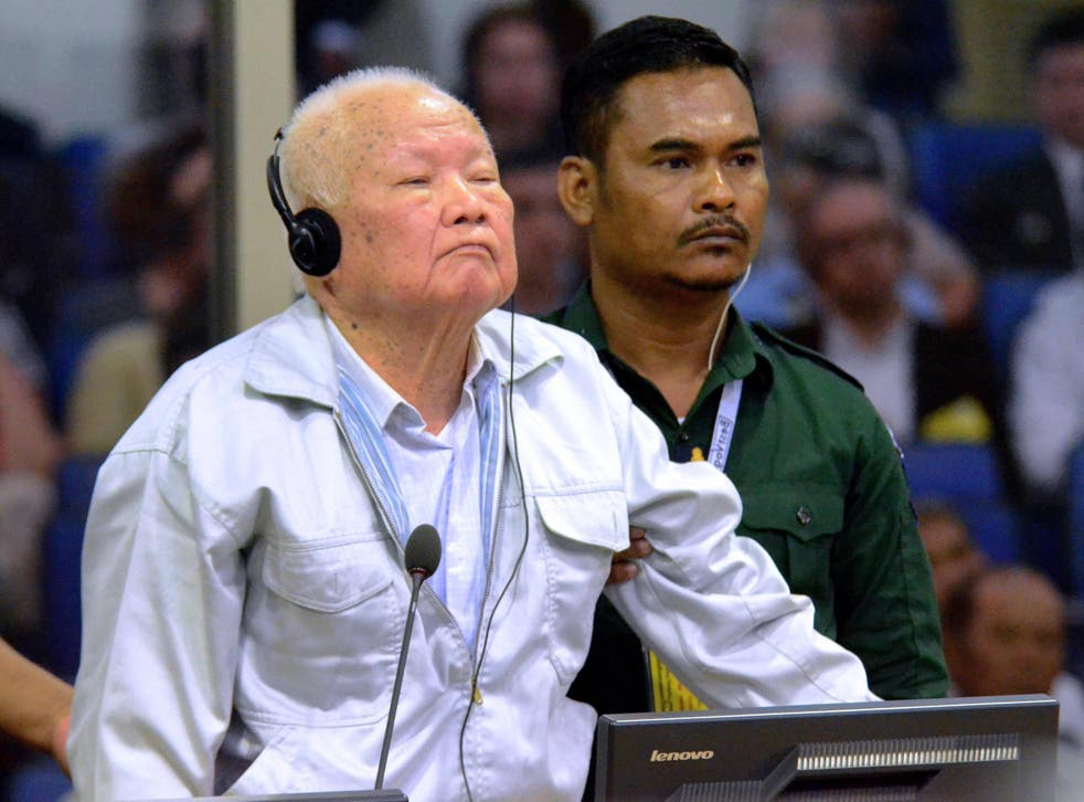 Khieu Samphan (L) stands during his verdict in court at the international tribunal in Phnom Penh