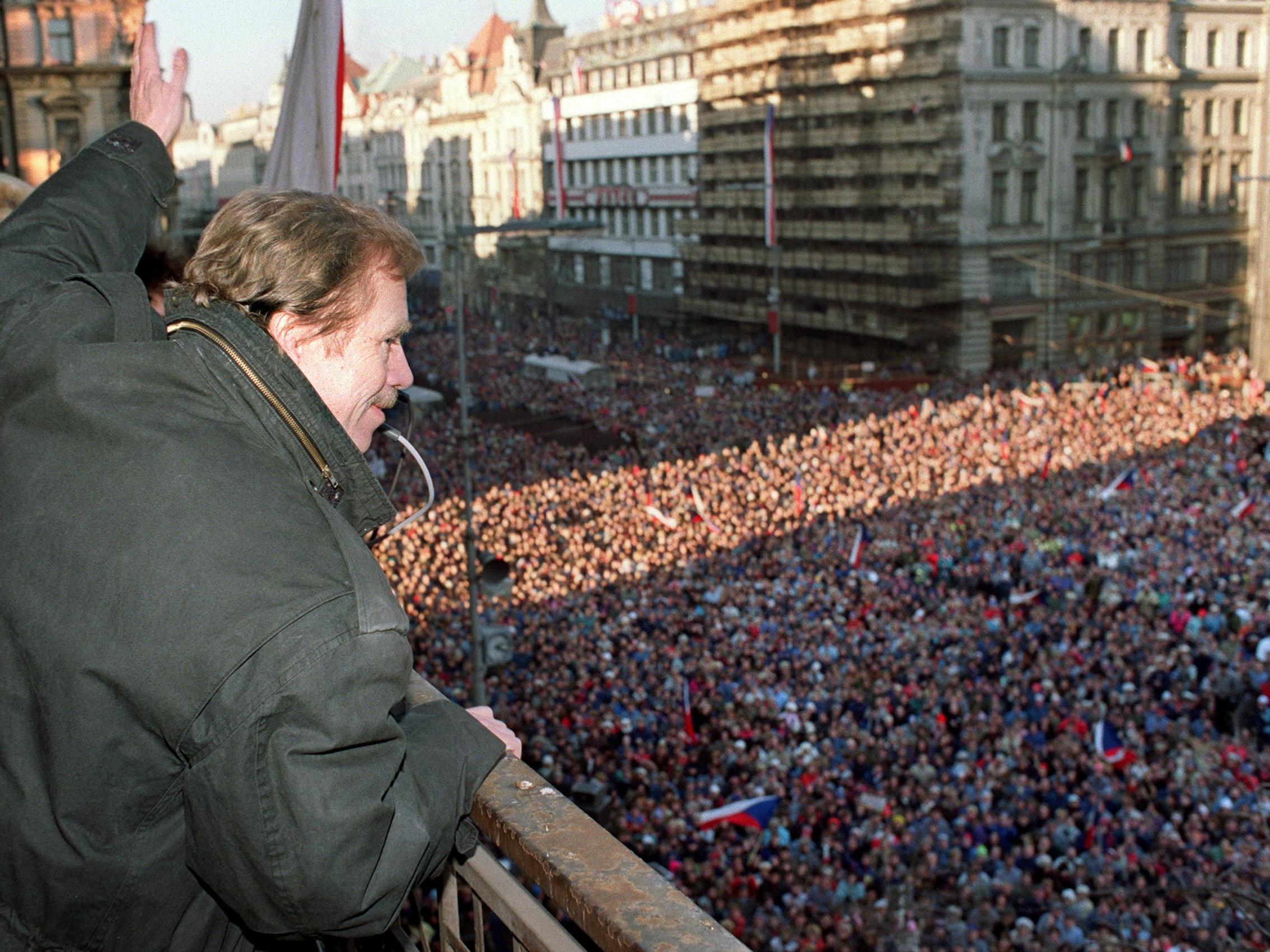 Vaclav Havel, a dissident playwright and leading member of the Czechoslovak opposition Civic Forum, waves to the crowd of thousands of demonstrators gathered on Prague’s Wenceslas Square on 10 December 1989, celebrating the communist capitulation