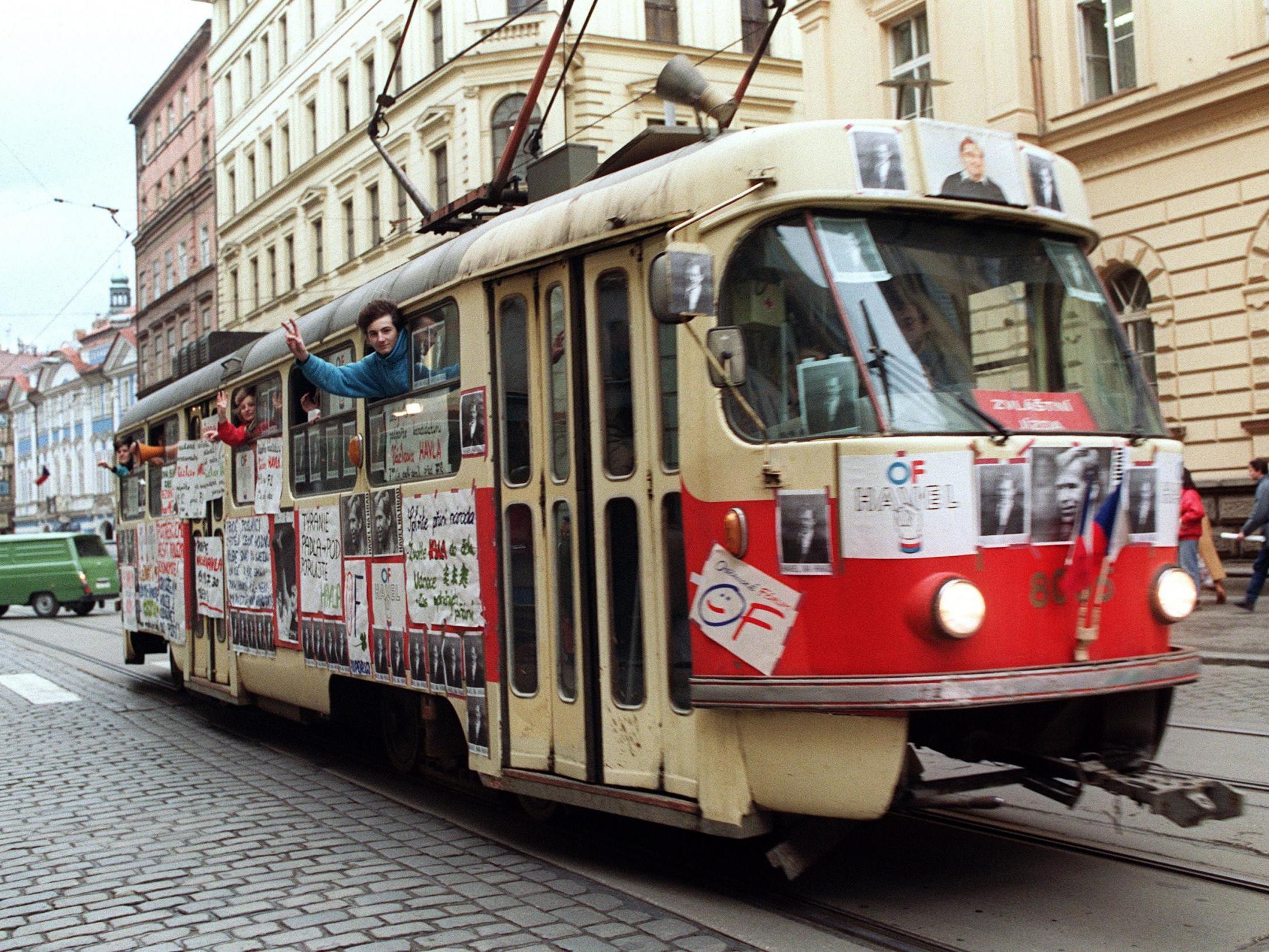 Young Czechoslovak people wave from a tramway in support of Vaclav Havel for presidency during a protest rally on 17 December 1989 near Wenceslas Square in Prague