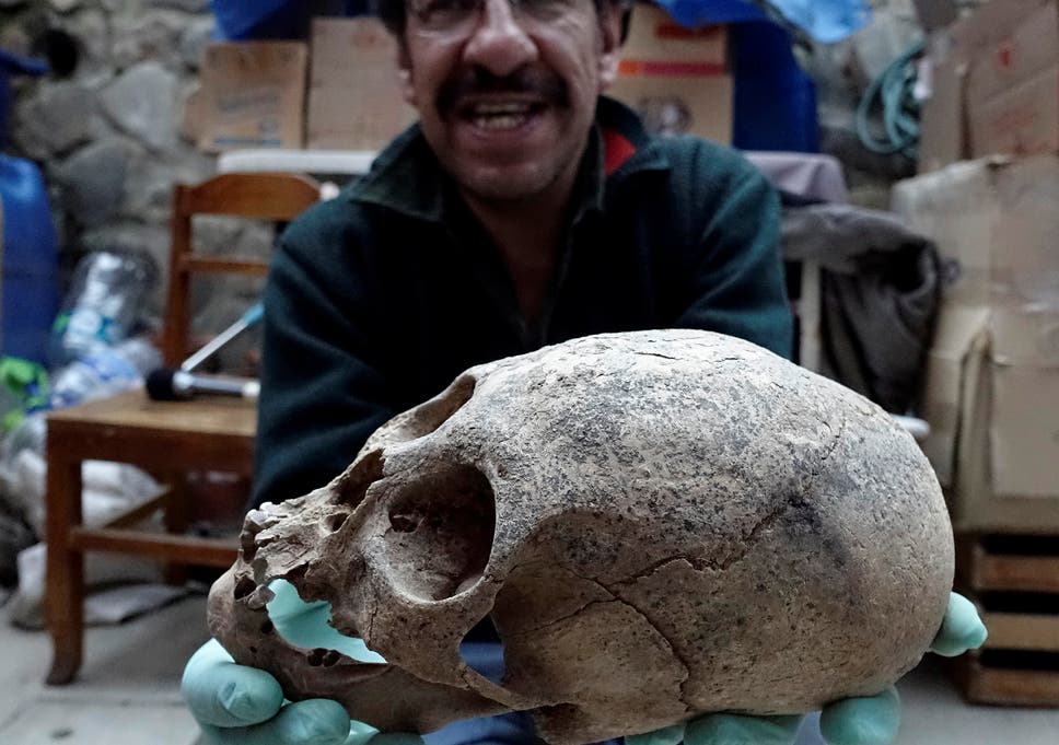 Archeologist Jedu Sagarnaga holds a skull as part of an archeological finding, dated approximately 500 years ago, in Mazo Cruz, near Viacha, Bolivia, November 12, 2018