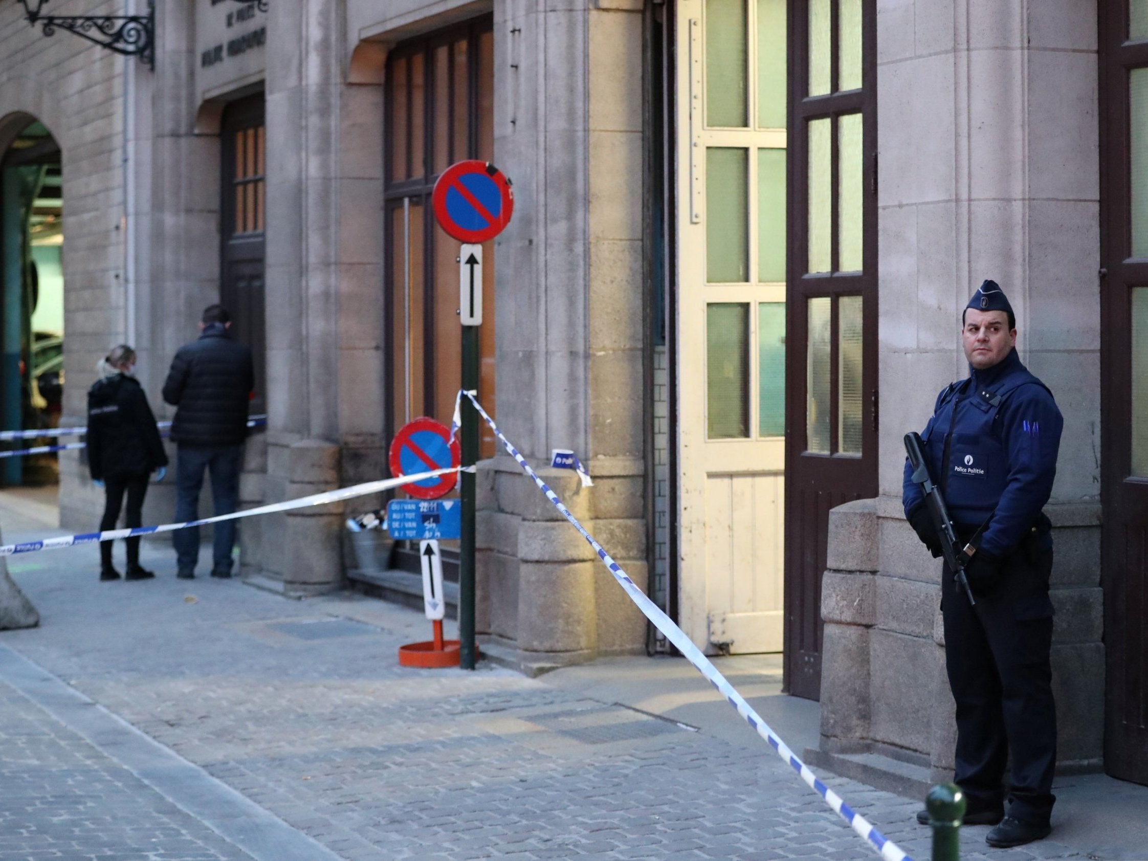 Police keep watch outside the police headquarters after a policeman was stabbed in Brussels