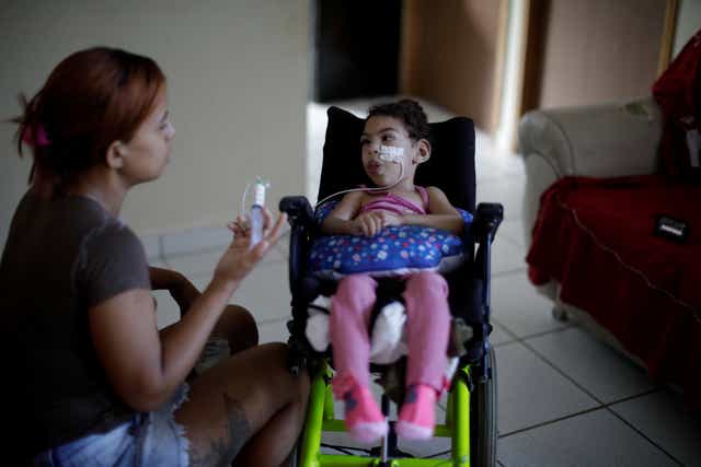 <p>Rosana Vieira Alves feeds her two-year-old daughter Luana Vieira, who was born with microcephaly, at their house in Olinda, Brazil</p>