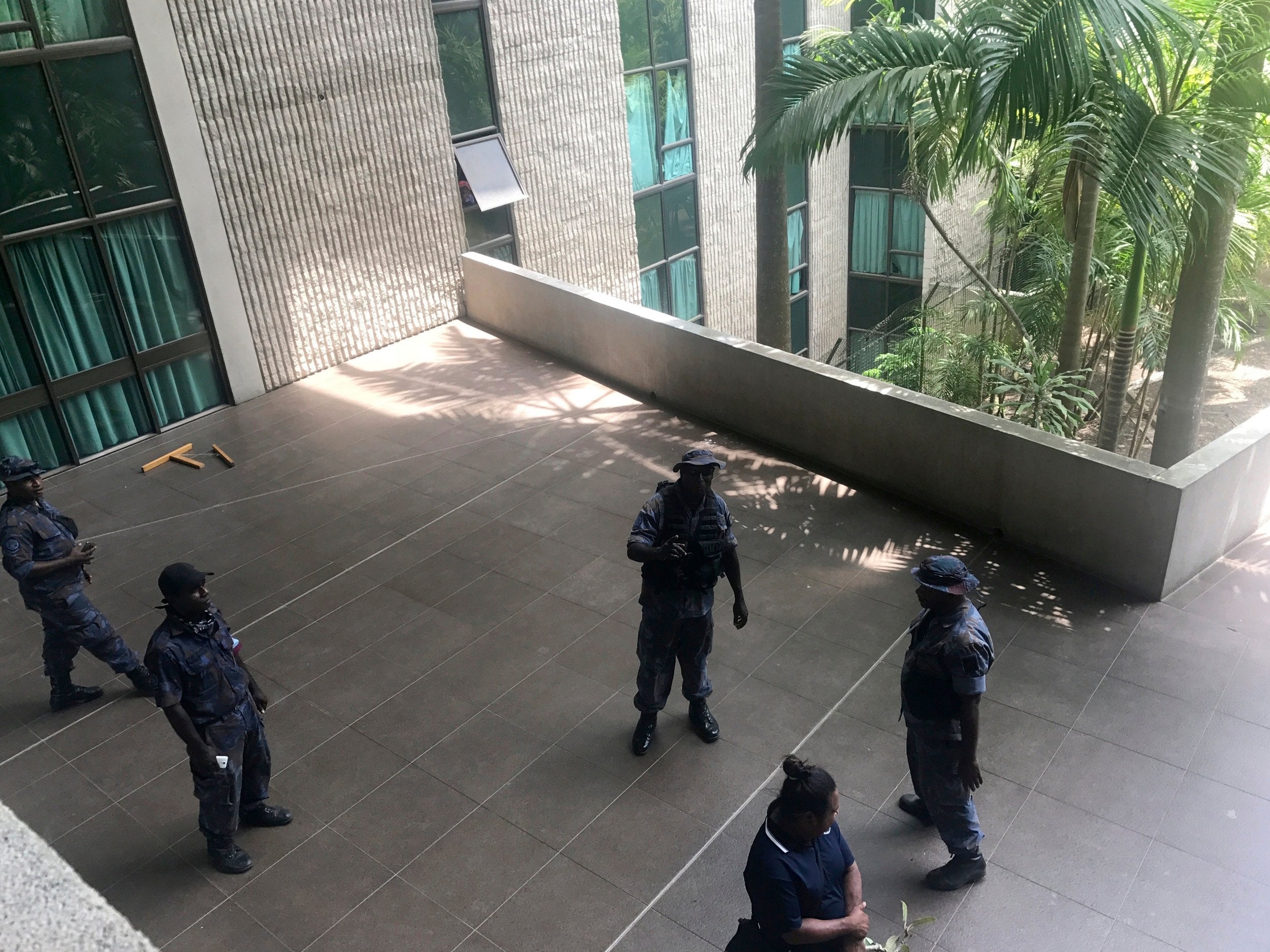 Police and soldiers guard the outside of parliament in Port Moresby after earlier, protesters stormed the building in a pay row