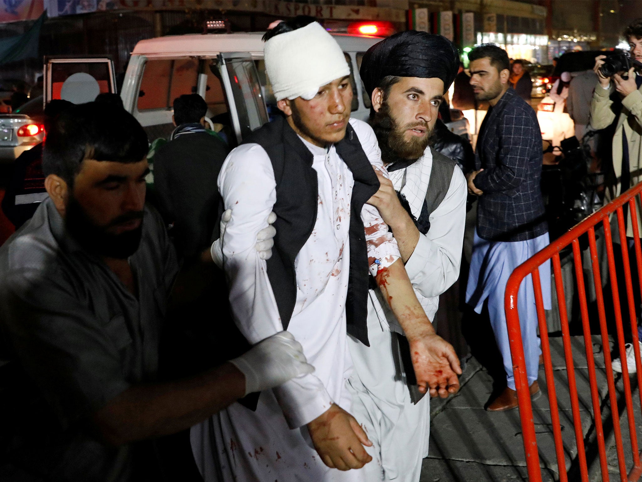 Men help one of the injured after the blast in a large wedding hall