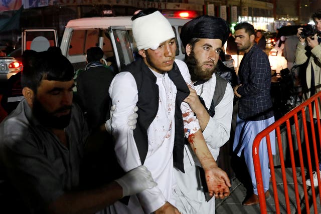 Men help one of the injured after the blast in a large wedding hall