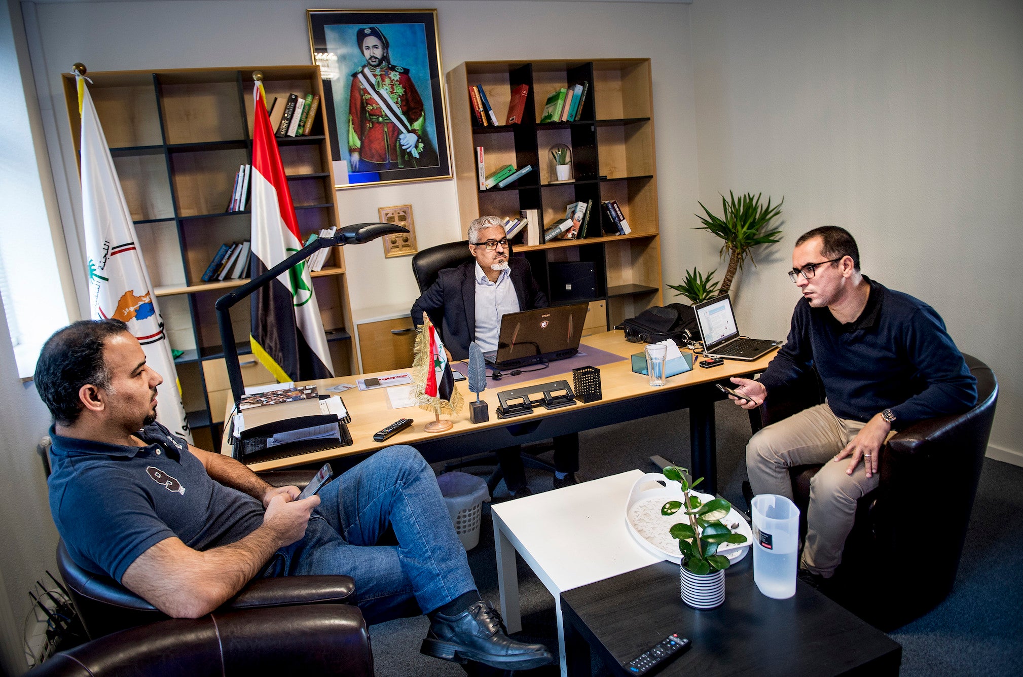 Habib Jabor, centre, and other members from the ASMLA group meet in an office in Ringsted (EPA-EFE)