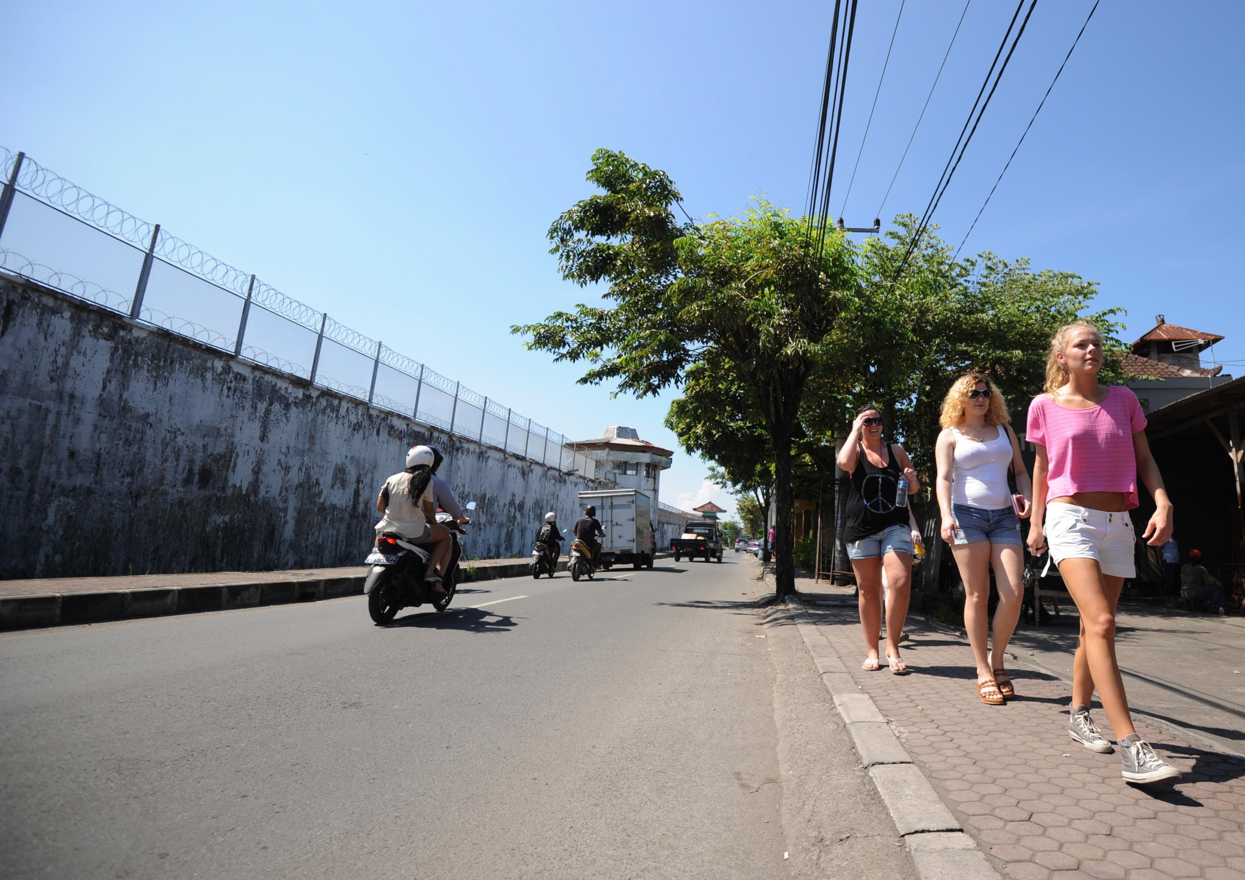Tourists walk along a street in Denpasar, where an American woman allegedly threw her baby from a moving car