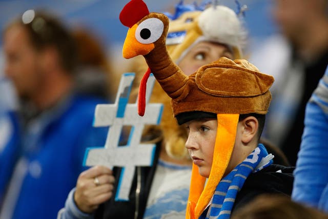 An NFL fan wears a turkey hat to a Thanksgiving game